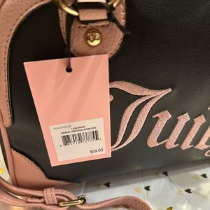 Pink and black, juicy couture bag, shoulder strap, as well as handles.